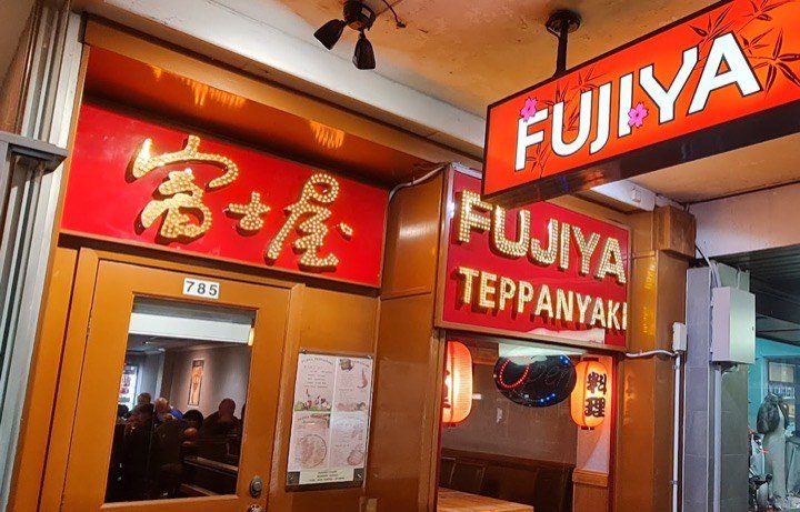 Fujiya’s shopfront on Pacific Highway, Gordon, at night: red signs reading 富士屋 and Fujiya Teppanyaki in gold bulb lettering, red lanterns in the window and the timber door at number 785
